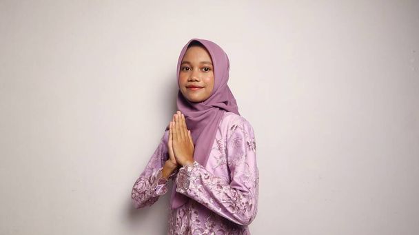 usmívající se indonéské dospívající dívky na sobě kebaya a hidžáb gestikulující pozdravy na izolovaném bílém pozadí - Fotografie, Obrázek