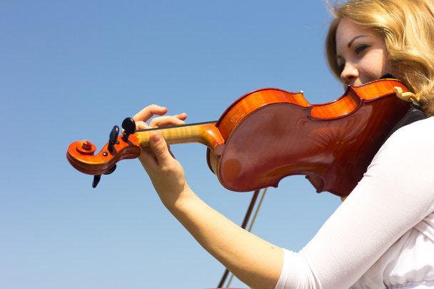 Girl playing on the violin outdoors. Musician for the wedding.Violin under the open sky - Фото, изображение