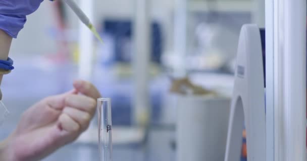 Medizinisches Personal entnimmt Proben aus dem Reagenzglas mit langer Pipette in Labornahaufnahme. Entwicklung der Pharmazie aus Infektionskrankheiten - Filmmaterial, Video