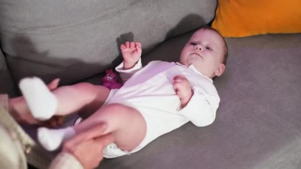 υγεία των παιδιών, φροντίδα των γυναικών γονέας κάνει ασκήσεις στο μικρό μωρό στον καναπέ, top view - Πλάνα, βίντεο