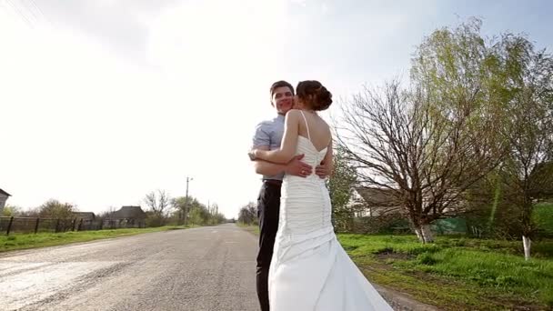 Bride and groom embrace on the road - Footage, Video