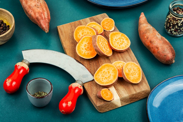 Sweet potatoes or batatas, board and knife . Dietary food. Vegetables. - Photo, Image