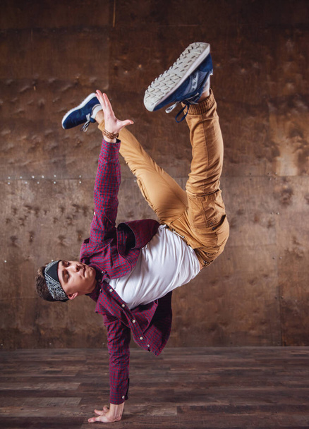 Jonge man break dancing op de achtergrond muur uitvoeren van trucs - Foto, afbeelding