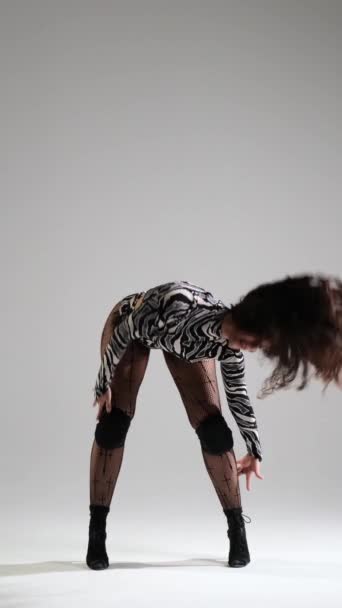 Професійна кавказька жінка-танцівниця, яка виступає сучасницею на сірому фоні. Показує гнучкість та енергетичний рух. Вертикальне відео. - Кадри, відео