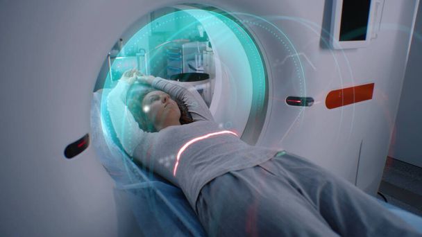 La mujer se somete a una resonancia magnética o tomografía computarizada procedimiento, se encuentra en la cama dentro de la máquina. Animación VFX de escanear el cerebro y el cuerpo del paciente femenino. Equipo avanzado de realidad aumentada en laboratorio médico moderno con Ai - Foto, imagen