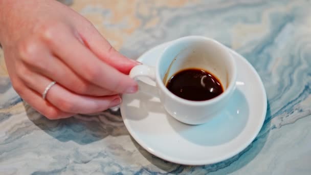 Close-up van een witte kop koffie op een marmeren tafel - Video