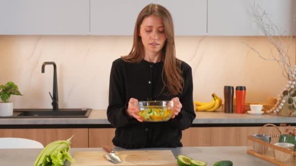 Filmación de una mujer joven mezclando verduras en rodajas en un tazón. - Imágenes, Vídeo