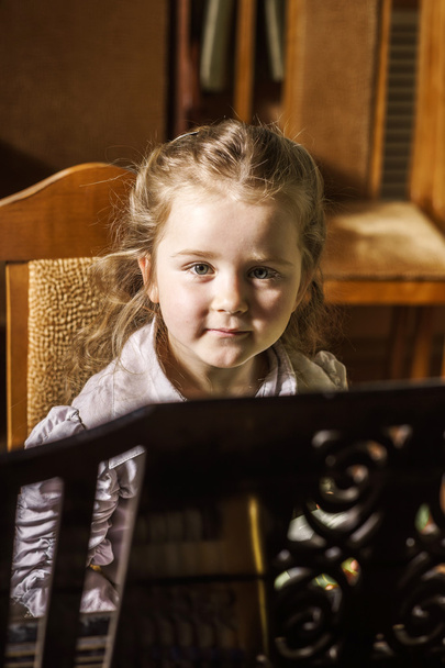 Cute little girl playing grand piano in music school - Foto, Imagen