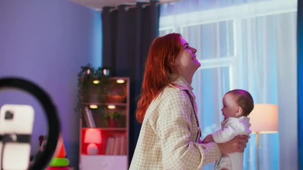 maternità, una donna felice divertirsi, getta un bambino piccolo e lo prende con le braccia nella bella stanza - Filmati, video