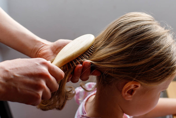 Detailní záběr mámy, jak čistí vlasy své dceři. péče o miminko - Fotografie, Obrázek