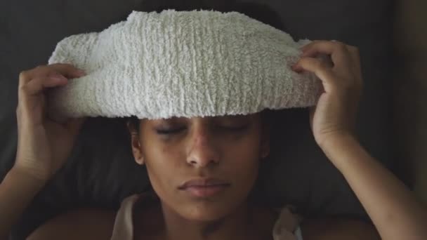 Top down close up tiro de menina doente com rímel borrado deitado na cama e aplicando toalha molhada na testa, tendo febre - Filmagem, Vídeo