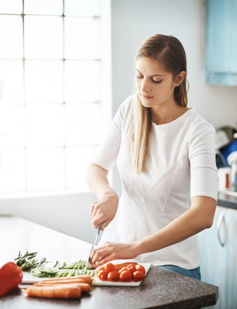 Woman, kitchen and cutting in vegetables, healthy and cooking at home, meal prep and nutrition. Vegetarian, organic and ingredients with food, diet and wellness or dinner, lunch in apartment. - Photo, Image