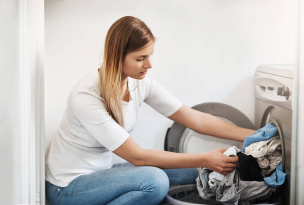 Woman, laundry and washing machine for clothes in home, electric appliance and routine housework. Female person, linen and fabric maintenance in apartment, sanitary and maid for hygiene housekeeping. - Photo, Image
