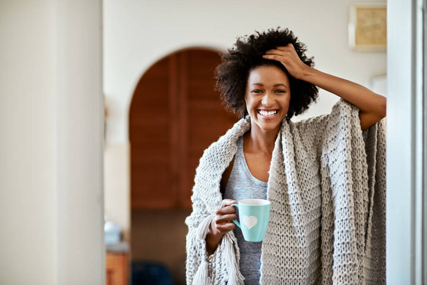 Černá žena, portrét a ranní káva doma, přikrývka a pohodlné v bytě. Žena osoba, latte a úsměv k relaxaci o víkendu, wellness a espresso nebo chlazení v salonku s kakaem. - Fotografie, Obrázek