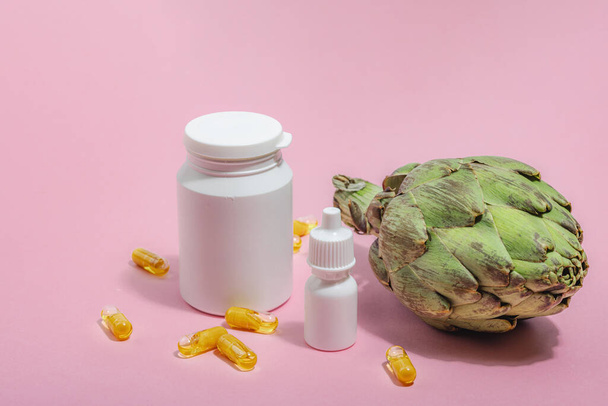 Dietary supplements Artichoke leaf extract capsules. Alternative medicine, beauty herbal lifestyle, healthy self care. Hard light, dark shadow, pink background, flat lay, close up - Photo, Image