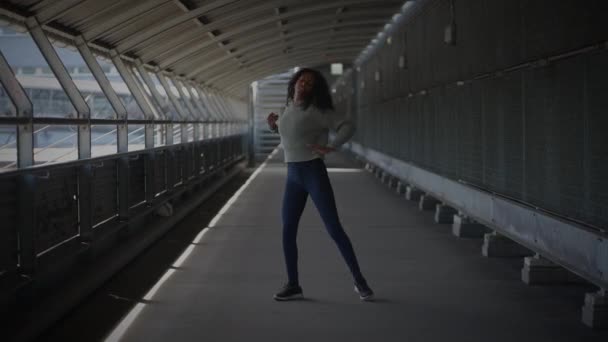 Onnellinen nuori nainen, jolla on kiharat hiukset Tanssi City Streetillä hitaassa liikkeessä  - Materiaali, video