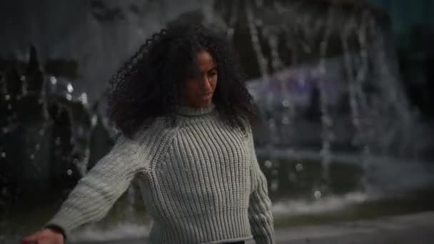 Glückliche junge Frau mit lockigem Haar tanzt in Zeitlupe auf der City Street  - Filmmaterial, Video