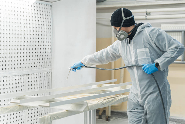 Hombre con máscara respiratoria pintando tablones de madera en el taller. Foto de alta calidad - Foto, imagen