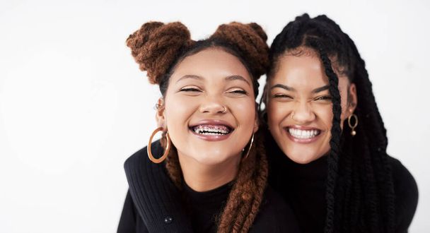 Lesbian couple, portrait and fashion in studio with hug for style inspiration, happiness and love together. Serious, lgbt and black people with embrace for support, relationship and braids with smile. - Photo, Image