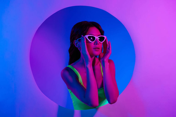 Фото девушки носить солнцезащитные очки прикосновение выглядят розовый пустой космос баннер изолированный неоновый цвет фона. - Фото, изображение