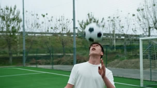 Jovem jogador de futebol adolescente faz dribles com a cabeça. - Filmagem, Vídeo