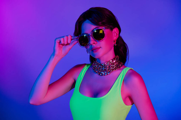 Photo of funky stylish girl wear summer retro sunglass look in camera isolated ultraviolet vivis color background. - Photo, Image