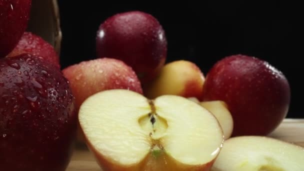 Makrográfia, szeletek friss alma van elrendezve egy vágódeszka ellen feltűnő fekete háttér. Minden közelkép rögzíti a ropogós textúrát és az almák élénk színeit. Érthető.. - Felvétel, videó