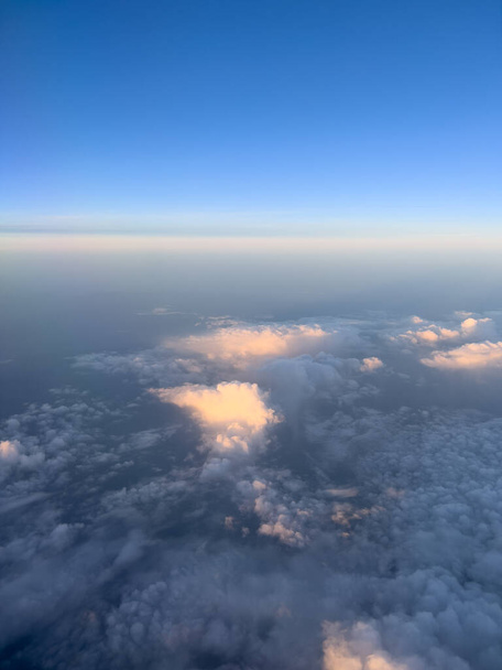 Cumulus clouds in sunbeams on a blue horizon. Top view. High quality photo - Photo, Image