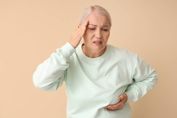 Kypsä nainen kärsii rintojen kipu beige tausta. Syöpätietoisuuden käsite - Valokuva, kuva