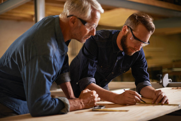 Family, father and son in a workshop, architect and woods with drawing or safety glasses with protection. Parent, men or teamwork with construction or building with planning for project or renovation. - Photo, Image