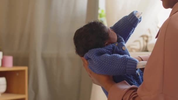 Soin jeune femme noire mettre bébé endormi sur le lit avec tendresse pendant la sieste de l'après-midi à la maison - Séquence, vidéo