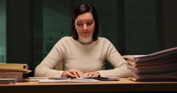 Büroangestellte schauen auf ihr mit Papieren überladenes Smartphone und sind bei der Arbeit bis spät in die Nacht nervös. Emotionen der Vorfreude und Überstunden - Filmmaterial, Video