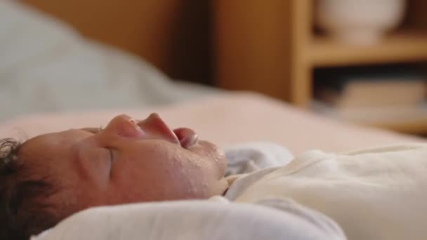 Close-up van kleine Afro-Amerikaanse slaperige baby liggend in bed, terwijl wakker in de ochtend - Video