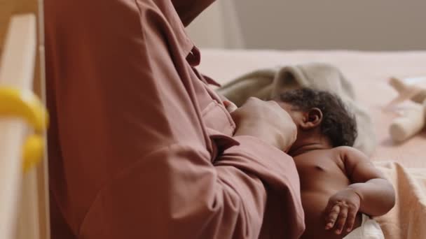Cropped shot of loving mother breastfeeding tiny baby on bed in their cozy apartment - Footage, Video