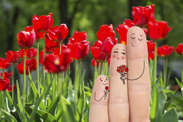L'art conceptuel du doigt familial. Père et fils donnent des fleurs à sa mère. Image de stock
. - Photo, image