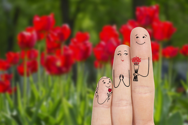 Conceptual family finger art. Father and daughter are giving flowers his mother. Stock Image. - Photo, Image