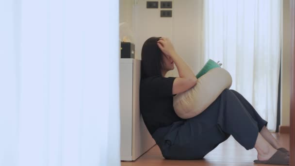 bienestar y bienestar concepto con mujer asiática tumbarse y leer libro en sala de estar - Imágenes, Vídeo