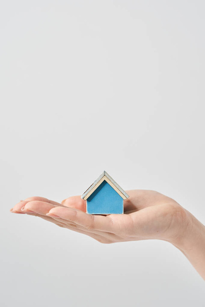 A house model held in the palm of a woman's hand and white background - Photo, Image