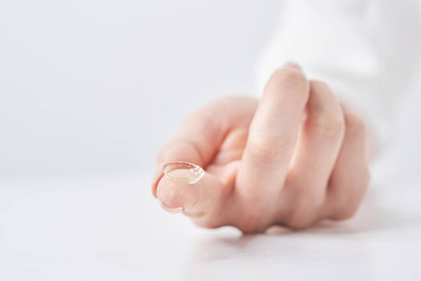 palce kobiety z soczewkami kontaktowymi i białym tłem - Zdjęcie, obraz