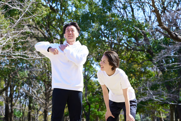 Чоловік і жінка роблять вправи для розігріву в день - Фото, зображення