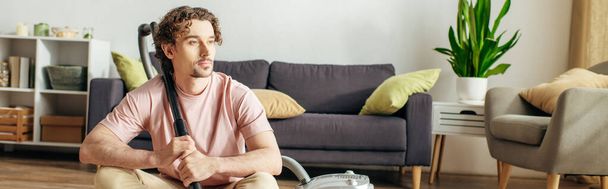 Un hombre guapo con ropa cómoda arregla su sala de estar. - Foto, imagen