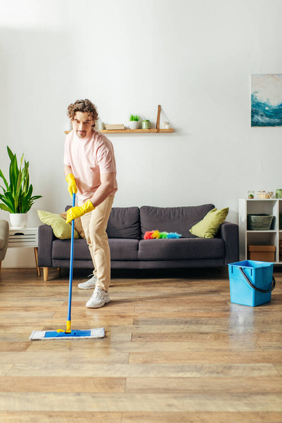 Bello uomo in accogliente casa pulizia pavimento con mop. - Foto, immagini