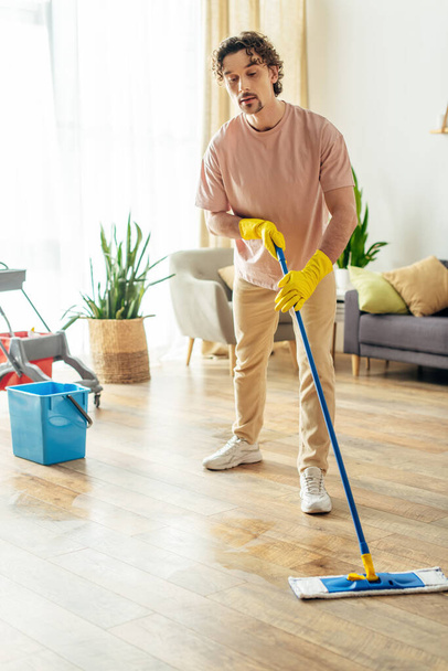 Handsome man in cozy homewear mopping the floor. - Photo, Image