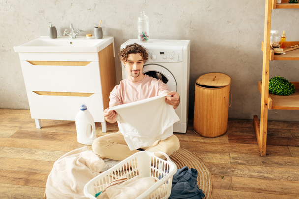 Jeune homme hypnotisé par la machine à laver. - Photo, image