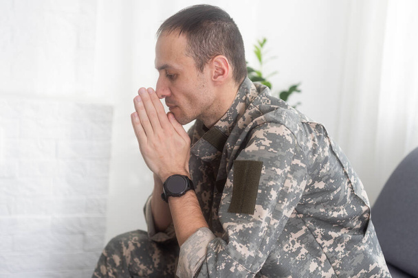 Hombre nervioso militar sufriendo depresión, sentado solo en casa, concepto de estrés postraumático. Foto de alta calidad - Foto, Imagen