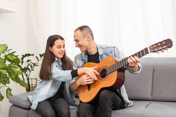 Ευτυχισμένη οικογένεια Πατέρας και κόρη παίζουν κιθάρα. Ημέρα πατέρων. Υψηλής ποιότητας φωτογραφία - Φωτογραφία, εικόνα