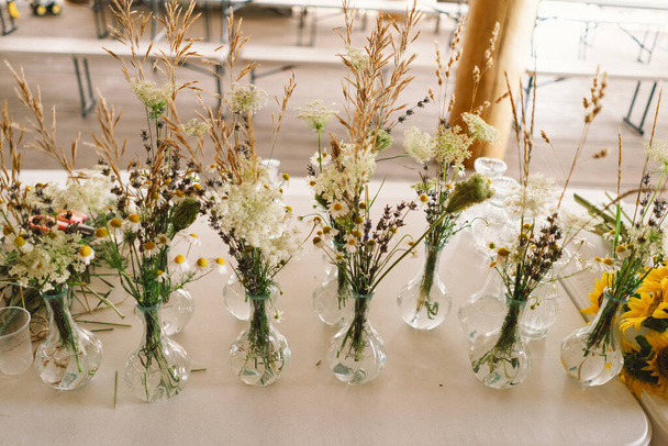 Elegant Wildflower Centerpieces Adorning a Festive Table at an Indoor Event of a long table - Photo, Image