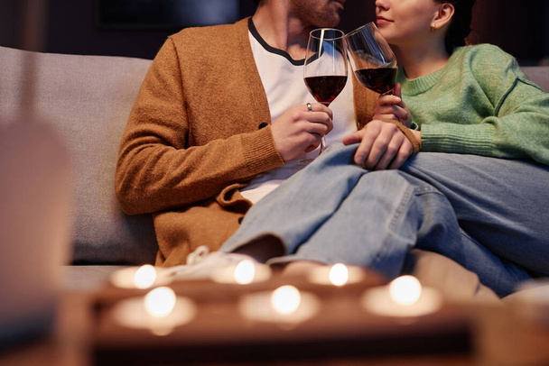 Κοντινό πλάνο του νεαρού ζευγαριού απολαμβάνοντας ρομαντική βραδιά στο σπίτι και πίνοντας κρασί, αντιγραφή χώρου - Φωτογραφία, εικόνα