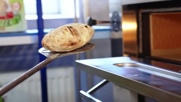 βγάζοντας ψωμί από φούρνο με φλούδα στην κουζίνα. Υψηλής ποιότητας 4k πλάνα - Πλάνα, βίντεο