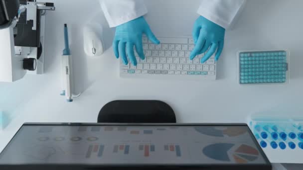 Γενετιστής σε ένα εργαστήριο υψηλής τεχνολογίας, όπου κάθε ένα από τα πειράματά της είναι ένα βήμα προς μια νέα ανακάλυψη. Κάτω από το μικροσκόπιο και στον υπολογιστή, μελετά τους γενετικούς μηχανισμούς της θεραπείας και - Πλάνα, βίντεο